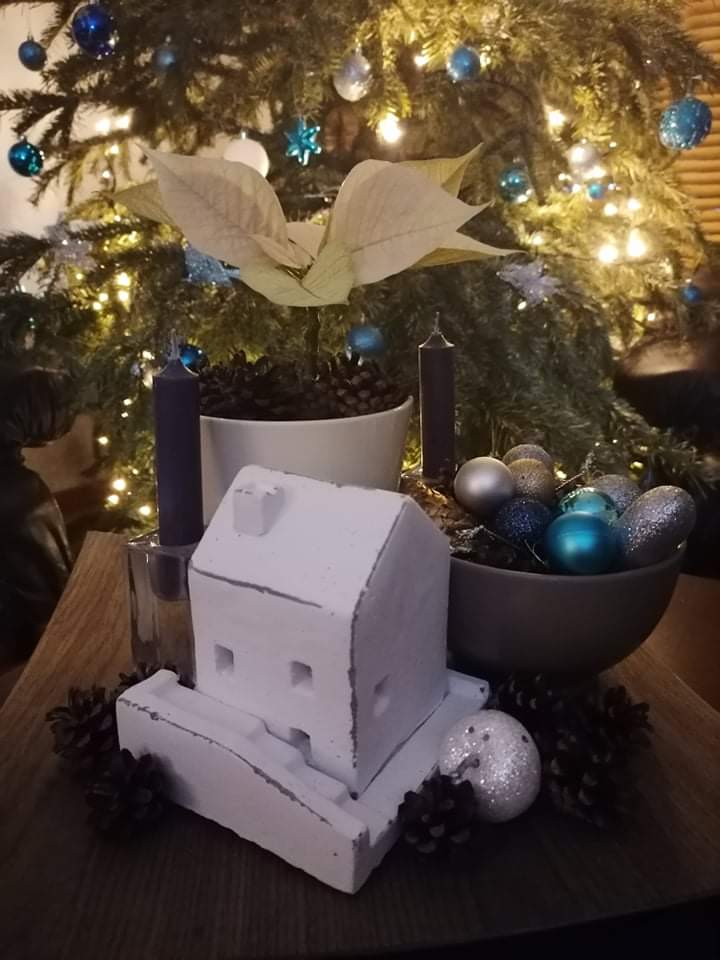 Betónový svietnik domček zakomponovaný do vianočnej výzdoby
